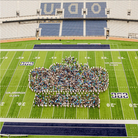 class of 2028 students in the shape of a crown on the football field